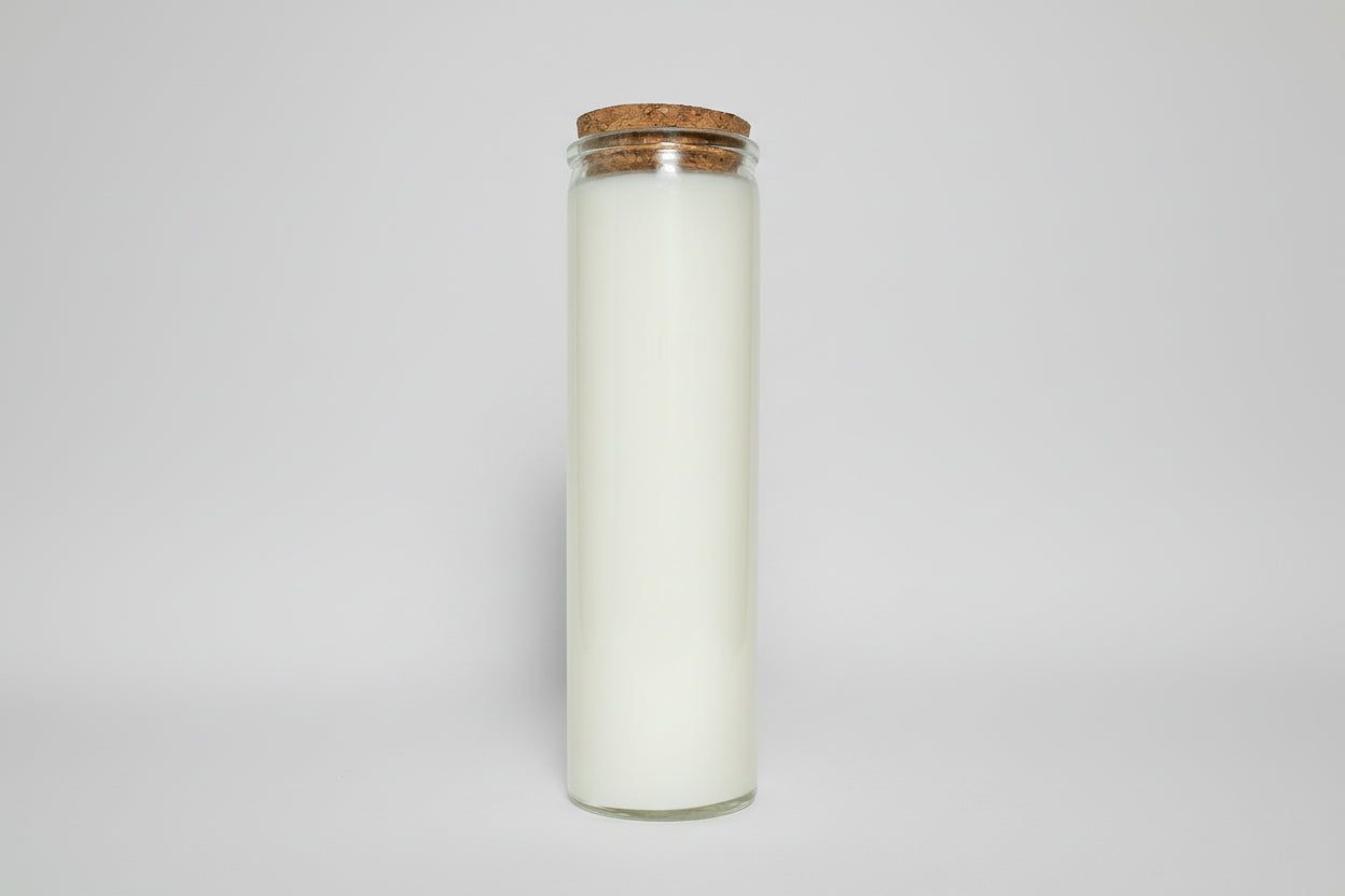 Candle in a glass jar with a cork lid on a white background