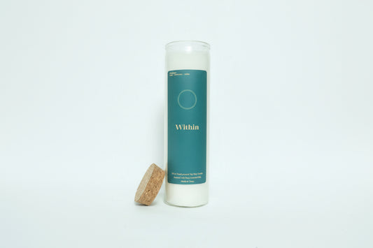 Candle with a teal label and cork lid on a white background