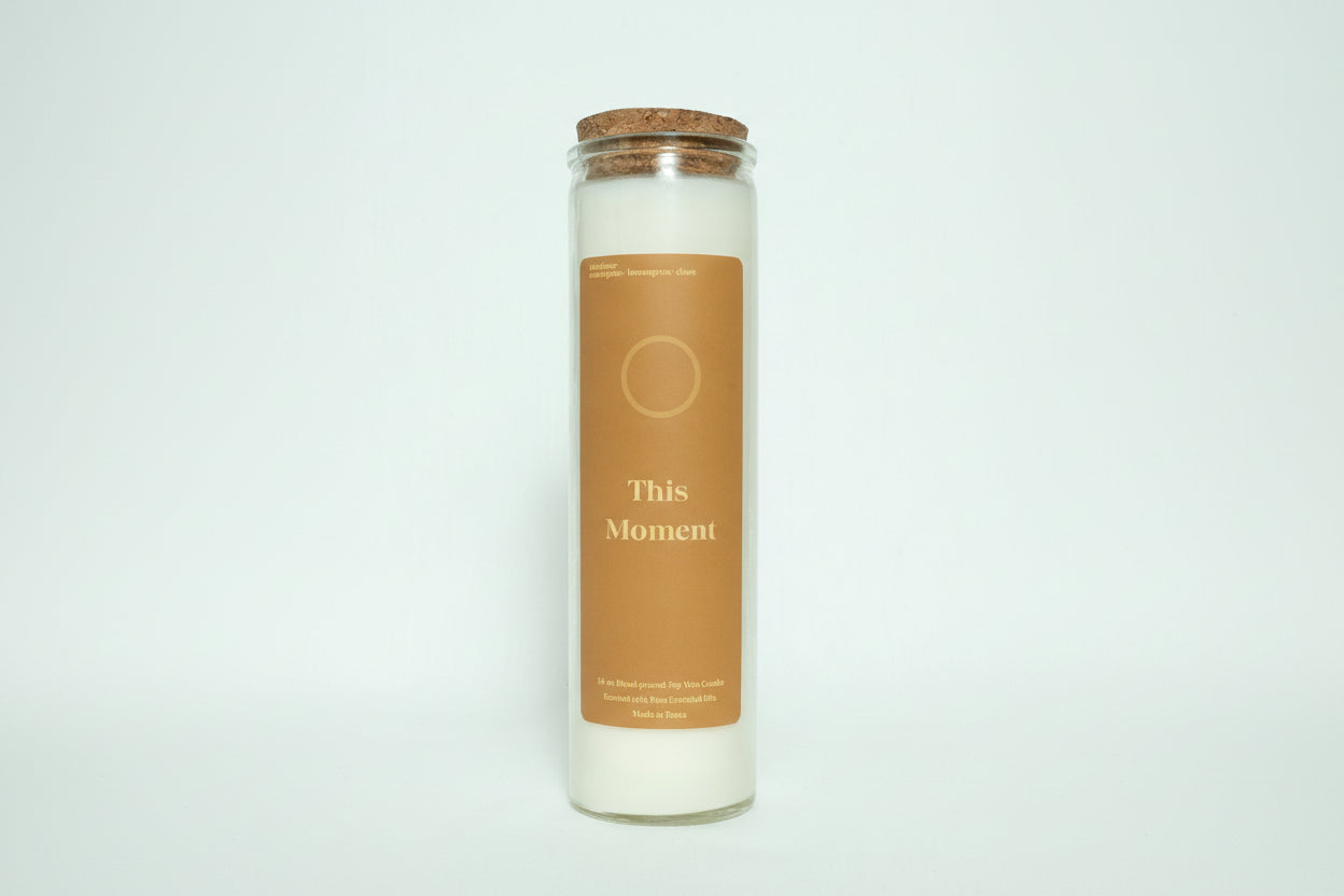 Candle in a glass jar with a cork lid on a white background